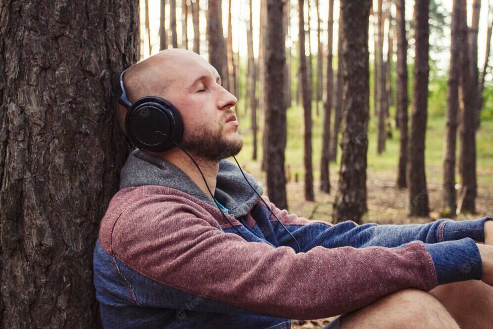 man-headphones-is-sitting-forest-with-his-back-tree_164357-3850.jpg